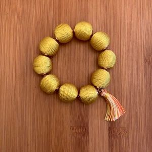 Yellow and gold woven bracelet with tassel